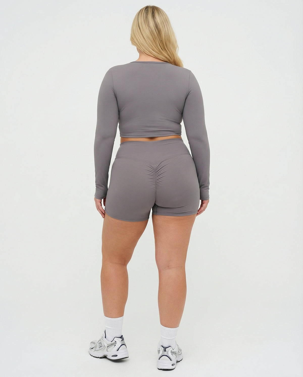 Seen women's activewear set with grey sculpting biker shorts and long sleeve top, designed for workout comfort and style.