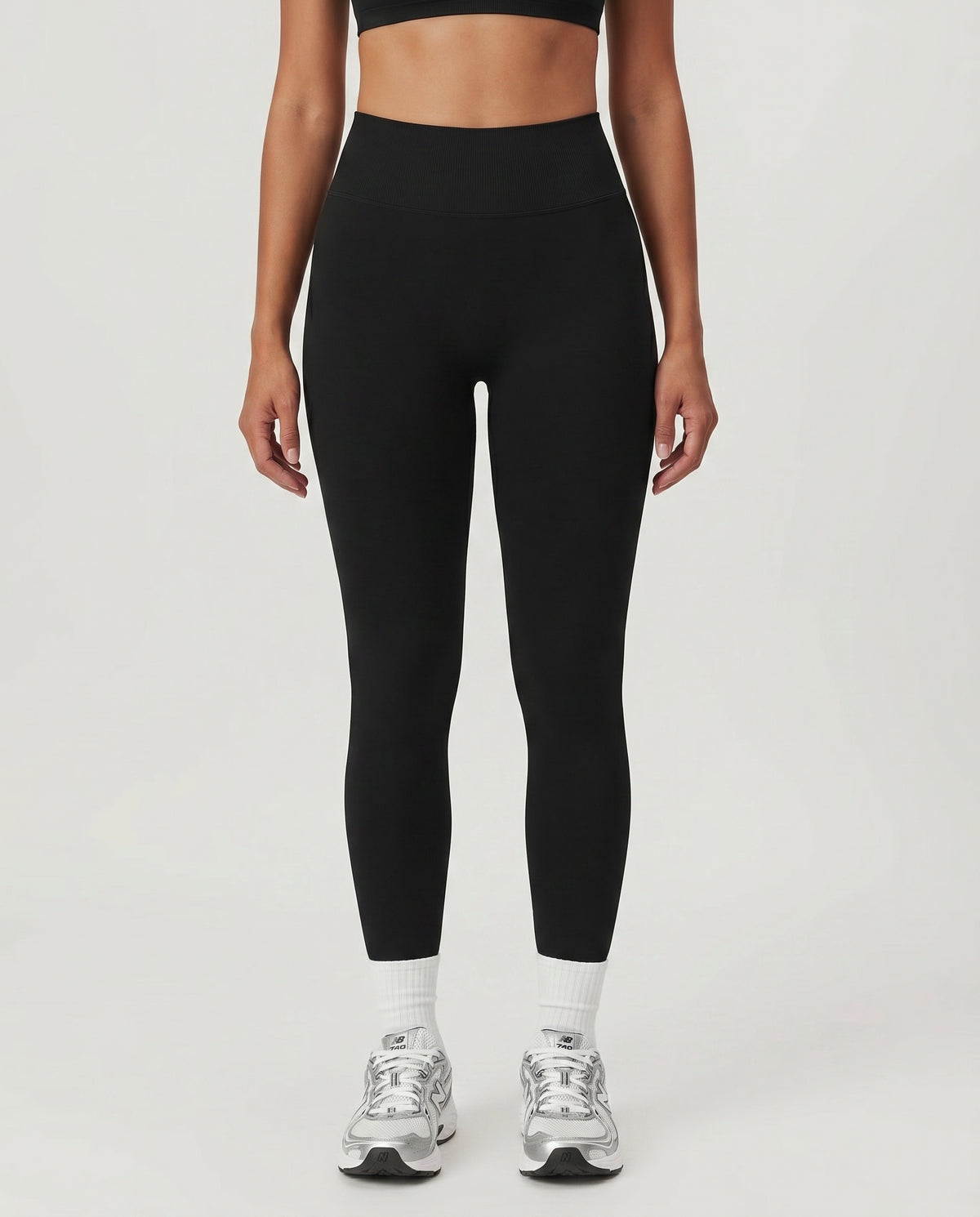 Front view of seamless high waist sculpting compression leggings in black, featuring a wide ribbed waistband and ankle-length squat-proof fit paired with white socks and silver sneakers.