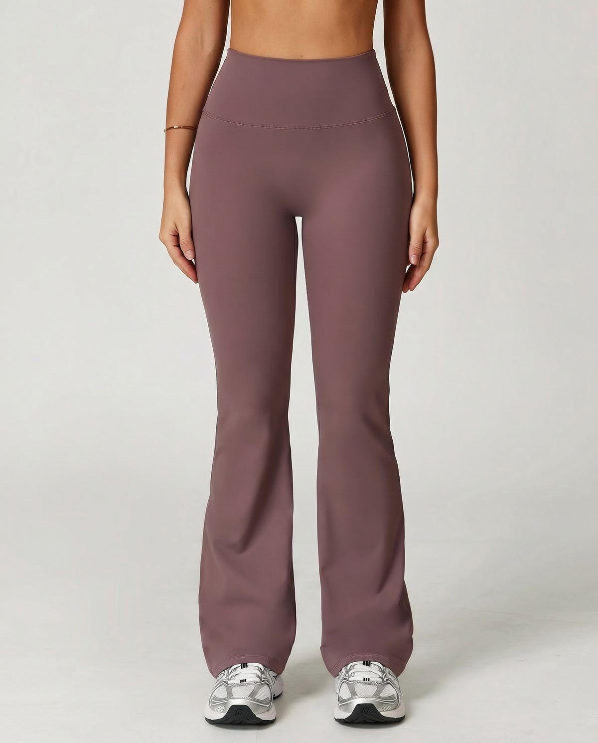 Front view of flare high waist sculpt yoga leggings in mauve, showing the wide sculpting waistband and leg-lengthening flare silhouette paired with white sneakers.