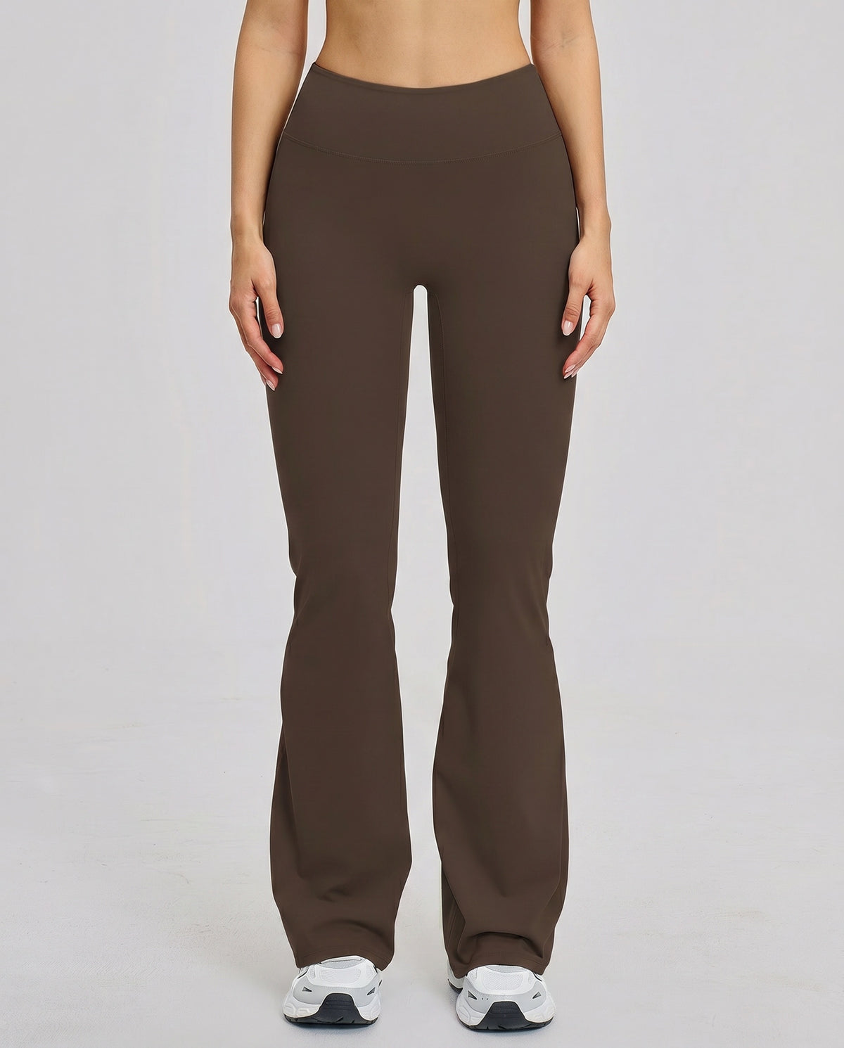 Front view of brown high waist flare leggings with sculpting compression fit and smooth waistband, styled with white sneakers.