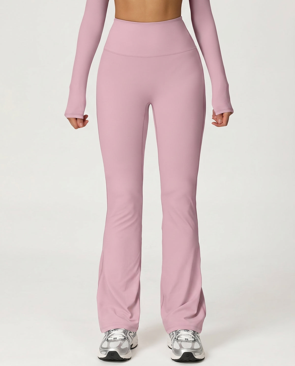 Front view of pink flare high waist sculpt yoga leggings with wide waistband and bootcut leg opening, paired with a matching long-sleeve top and sneakers.