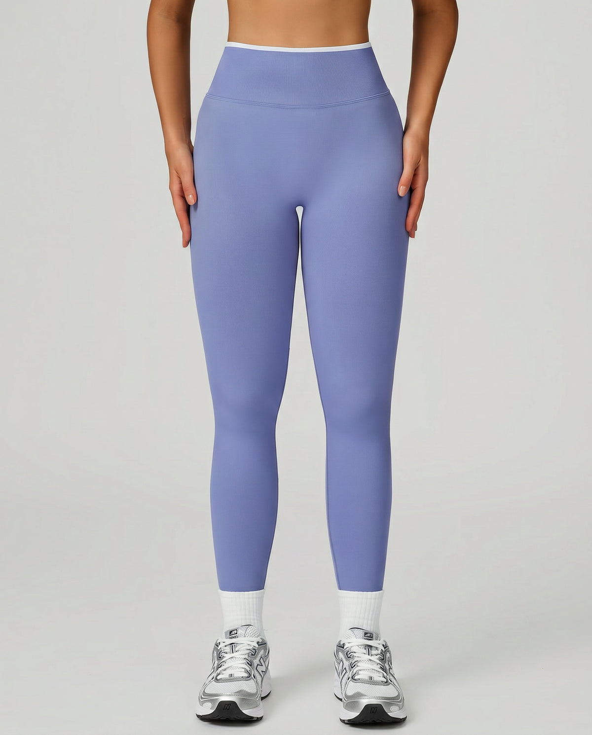 Front view of seamless high waist sculpting compression leggings in light blue, showing smooth waistband and full-length silhouette paired with white sneakers.