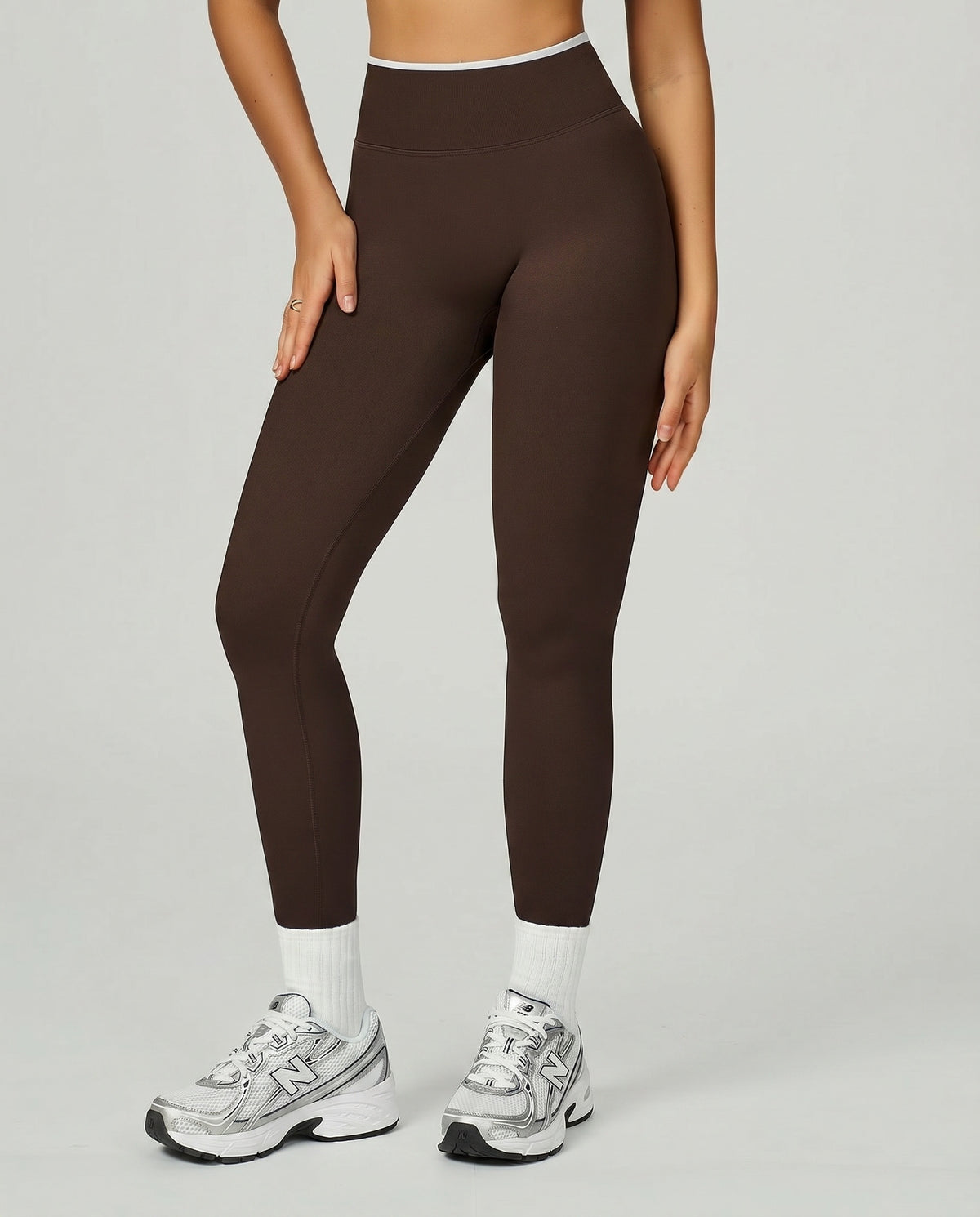 Front view of seamless high waist sculpting compression leggings in brown, styled with white socks and New Balance sneakers showing the full-length squat-proof fit.
