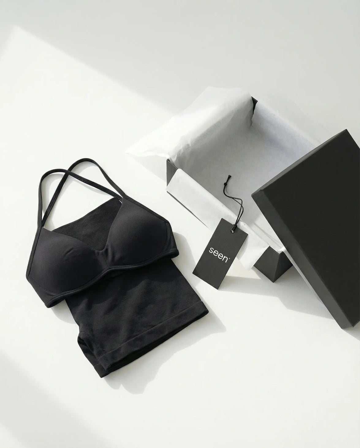 Model wearing a black seamless sculpt gym set with high waist shorts and a supportive sports bra paired with athletic sneakers.