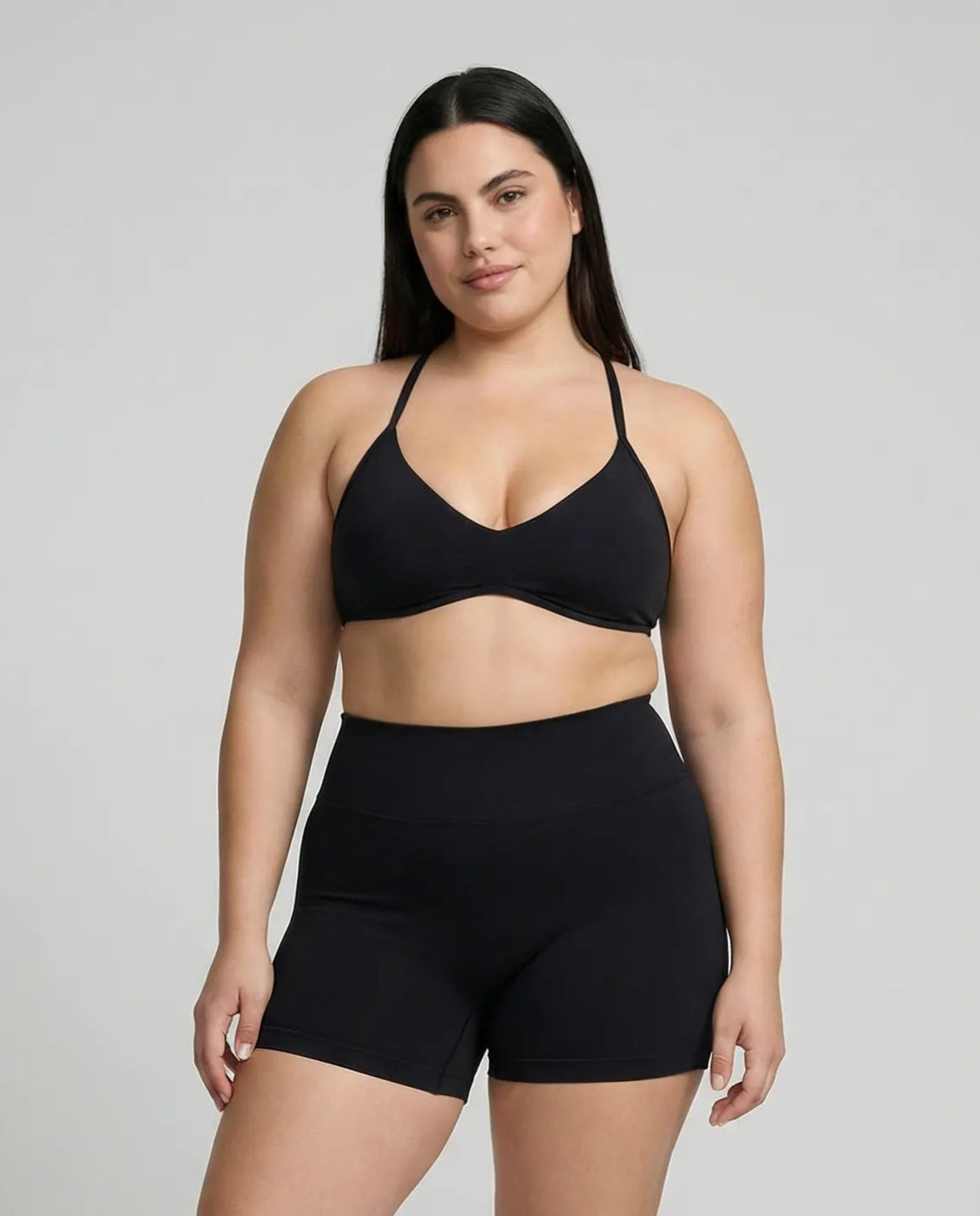 Model wearing a black seamless sculpt gym set with high waist shorts and a supportive sports bra paired with athletic sneakers.
