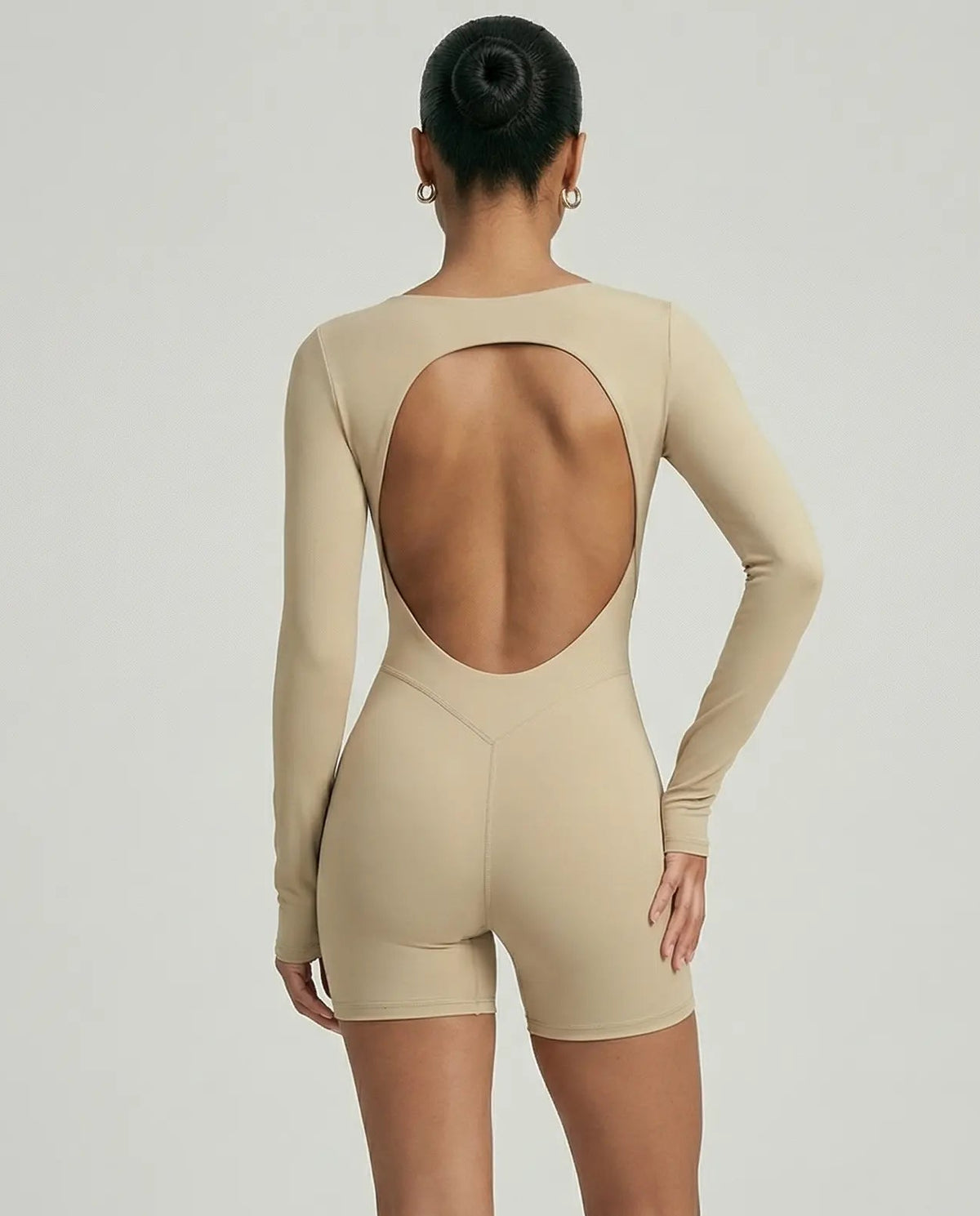 Woman wearing a long sleeve compression shorts sculpting romper designed for activewear and athleisure use.