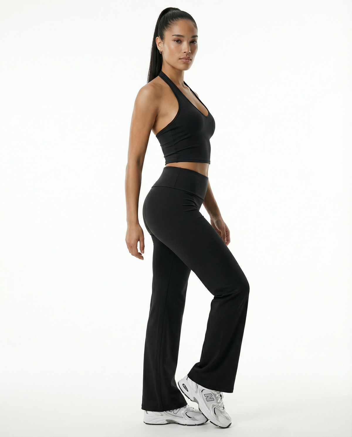 Seen flare yoga pants set with high waist and halter sports bra, shown in a stylish athletic pose on a white background.