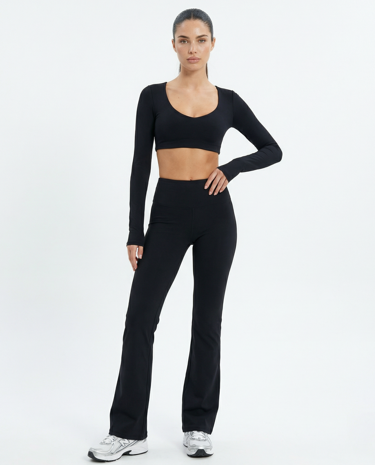 Seen flare yoga pants set with high waist and long sleeve crop top, shown in black on a model.