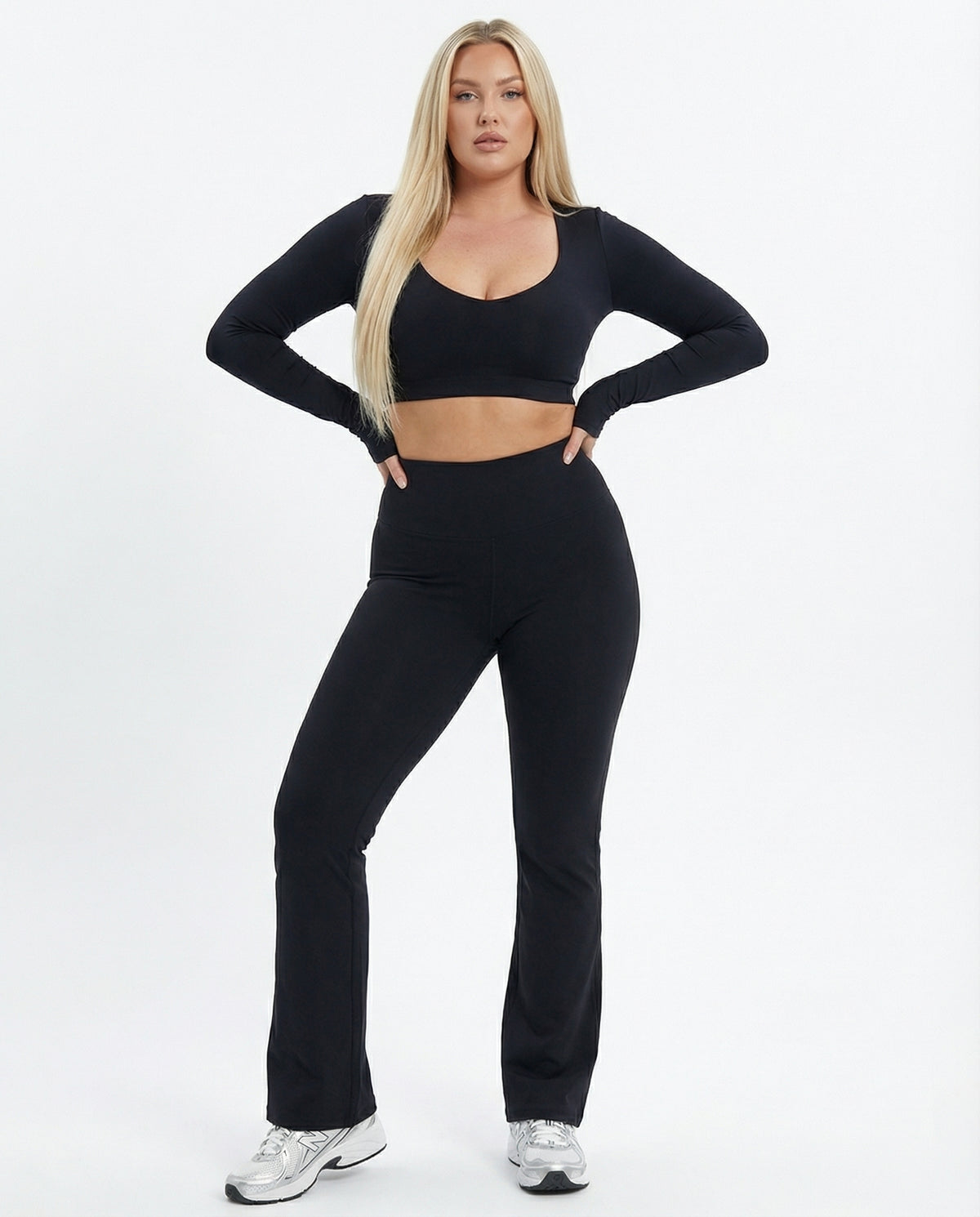 Seen flare yoga pants set featuring high waist and long sleeve crop top, shown on a model in a bright workout space.