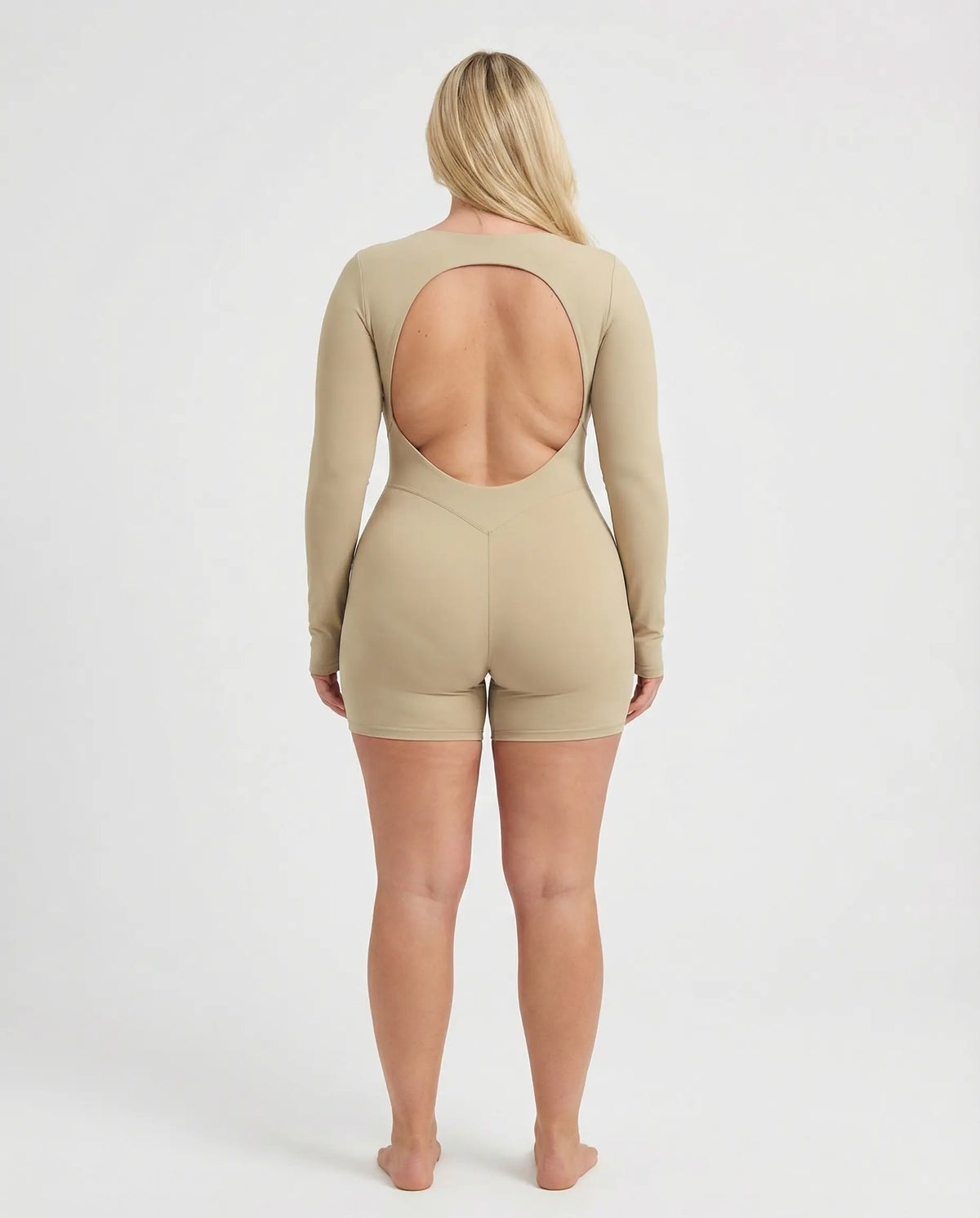 Woman wearing a long sleeve compression shorts sculpting romper designed for activewear and athleisure use.