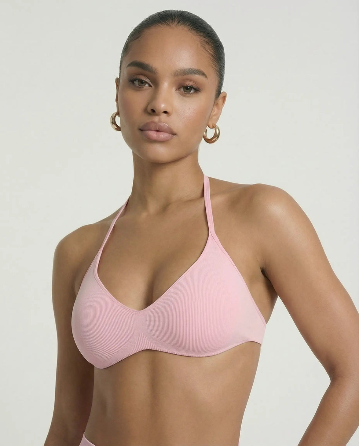 Model wearing a pink seamless sculpt gym set with high waist shorts and a supportive sports bra paired with athletic sneakers.