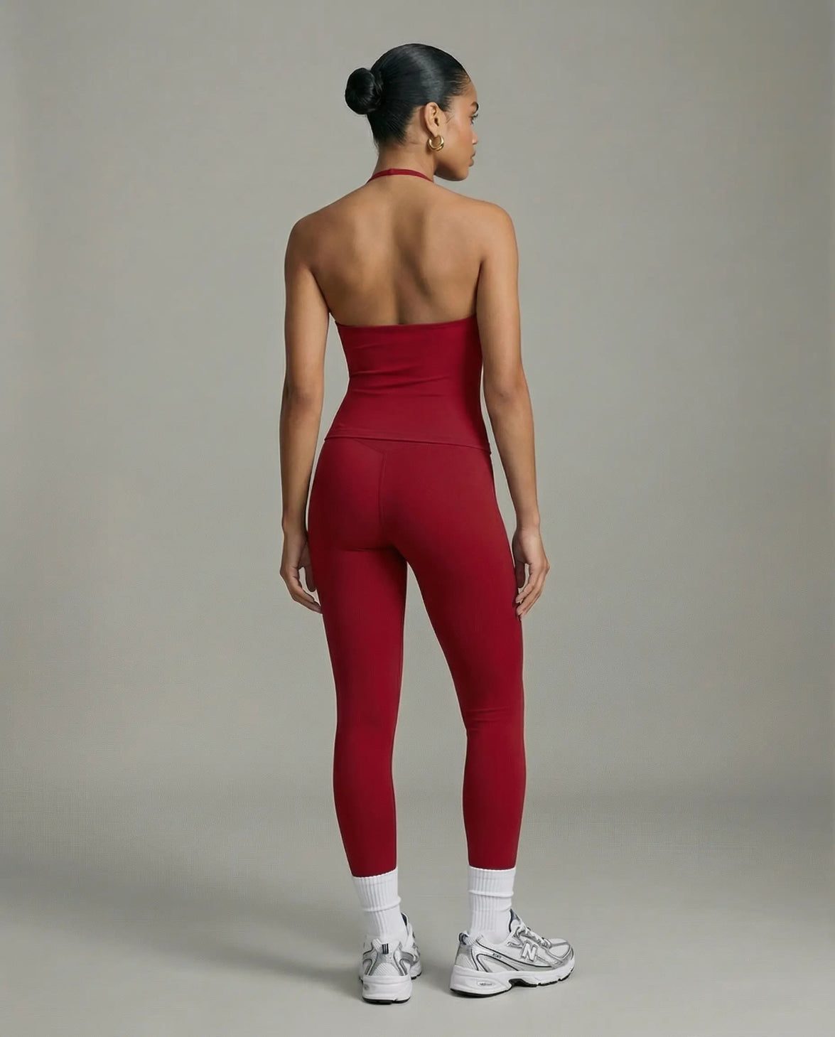 Model wearing a red seamless halter sculpt leggings set with high waist fitted leggings and athletic sneakers.