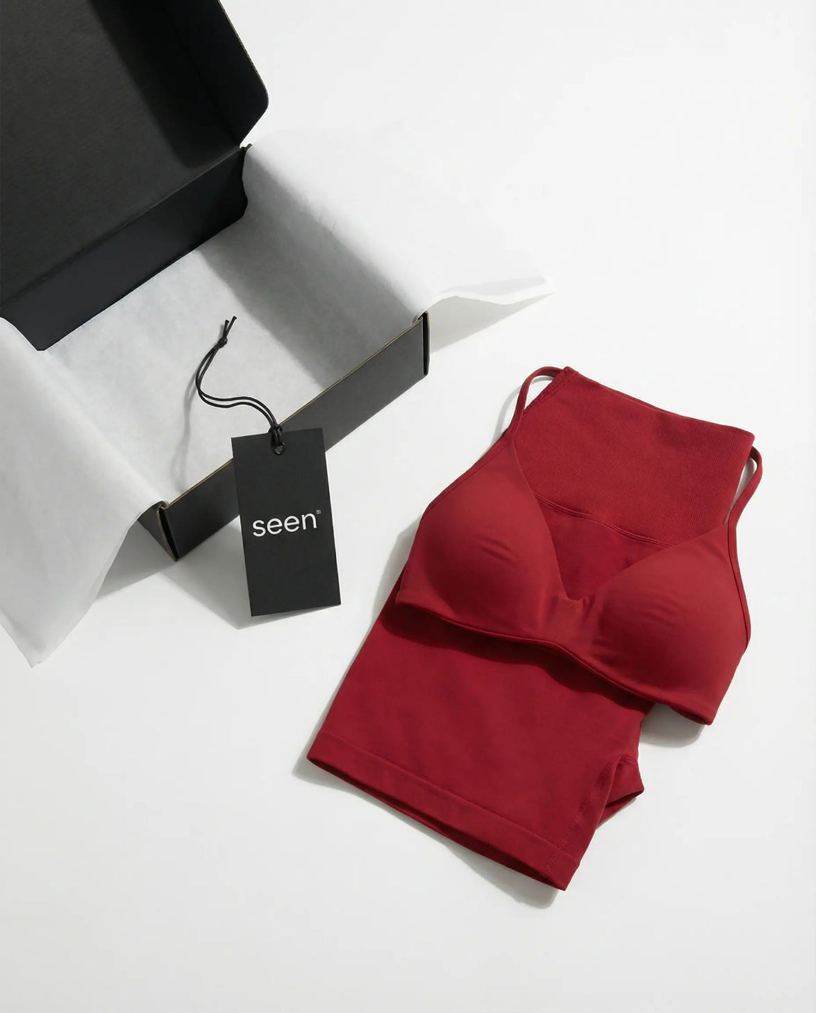 Model wearing a red seamless sculpt gym set with high waist shorts and a supportive sports bra paired with athletic sneakers.