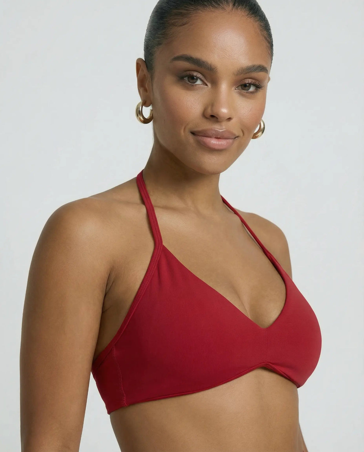 Model wearing a red seamless sculpt gym set with high waist shorts and a supportive sports bra paired with athletic sneakers.