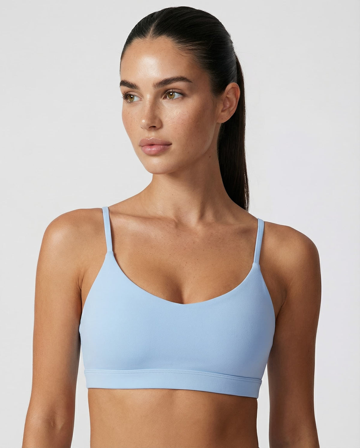 Woman wearing a seamless medium support workout sports bra with a smooth sculpting fit and minimalist design.