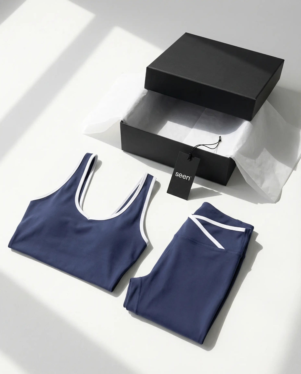 Woman wearing seamless sculpt high waist gym set with tank top and leggings in navy blue, shown from front and back.