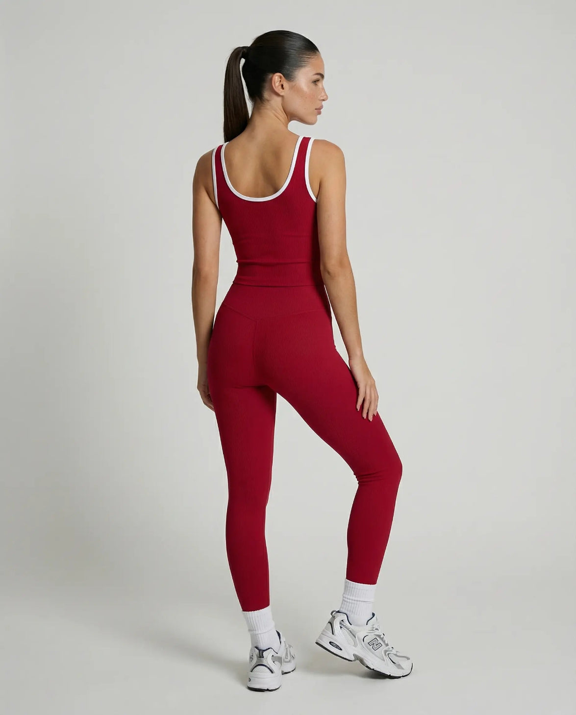 Woman wearing seamless sculpt high waist gym set with tank top and leggings in red, shown from front and back.