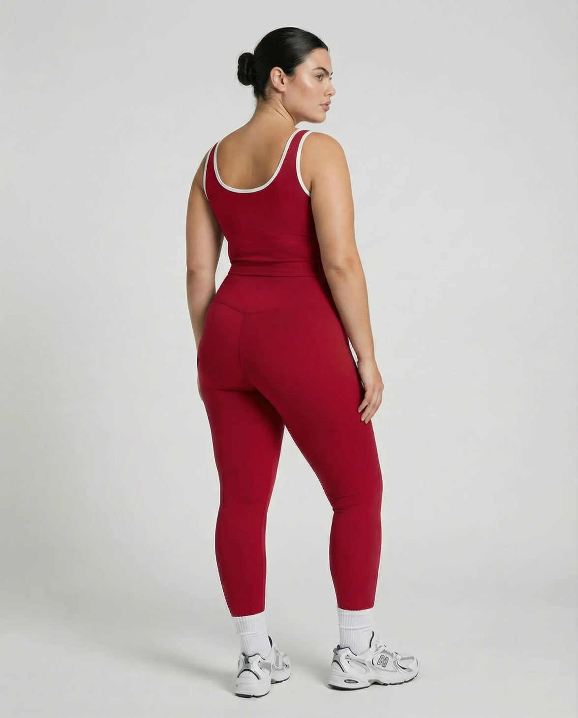 Woman wearing seamless sculpt high waist gym set with tank top and leggings in red, shown from front and back.