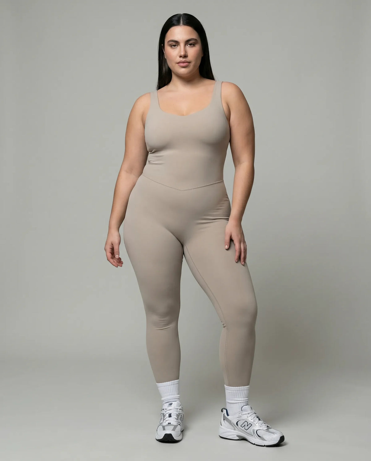Model wearing gray backless bodysuit in front studio pose showing sculpting fit and sweetheart neckline.