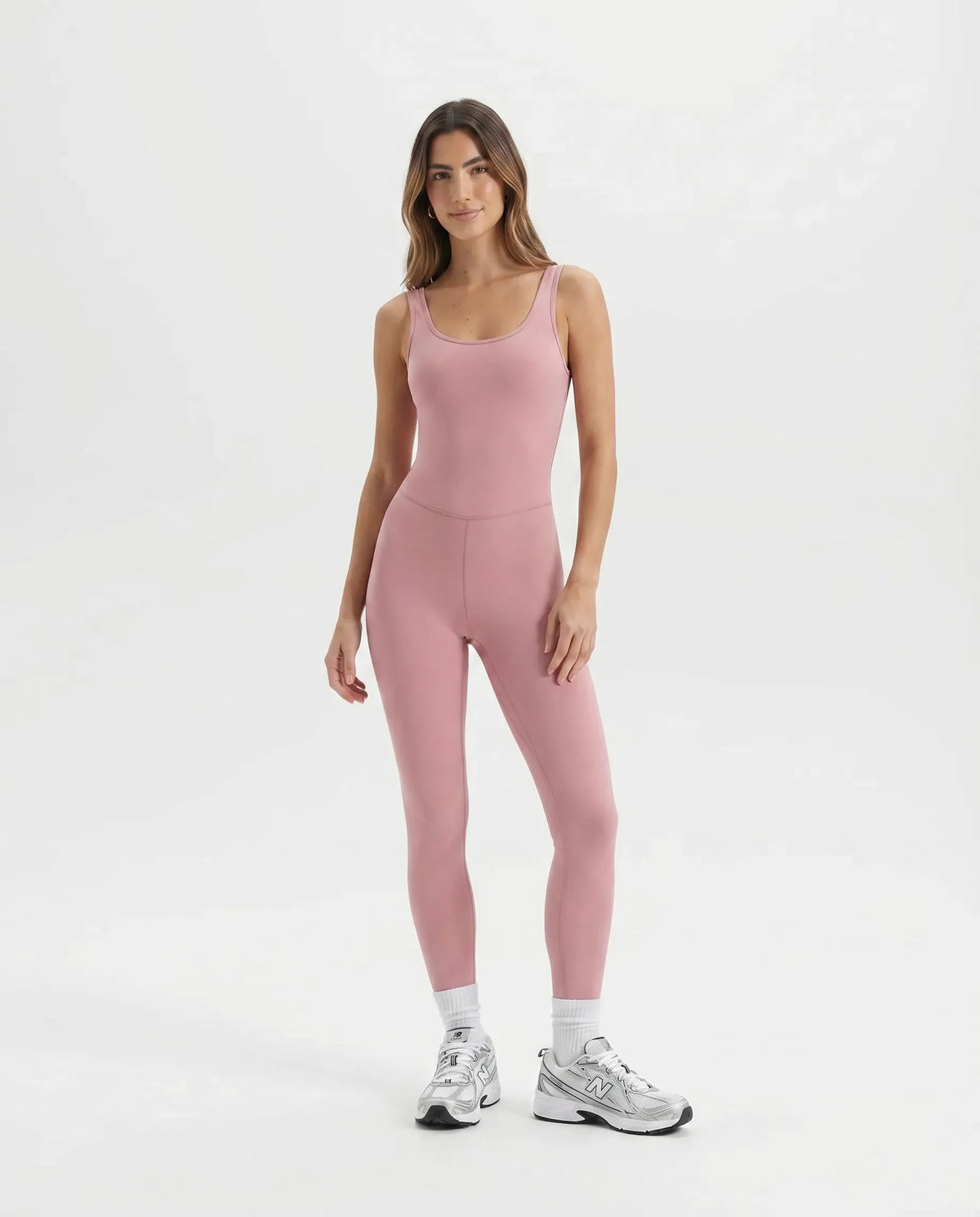 Ghost mannequin front view of pink backless full-length bodysuit showing scooped neckline and seamless waistline.
