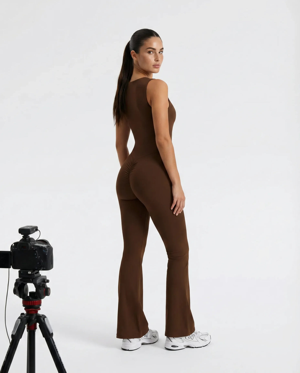 Back view of brown backless flare bodysuit on ghost mannequin highlighting the open back cut and clean seam lines.
