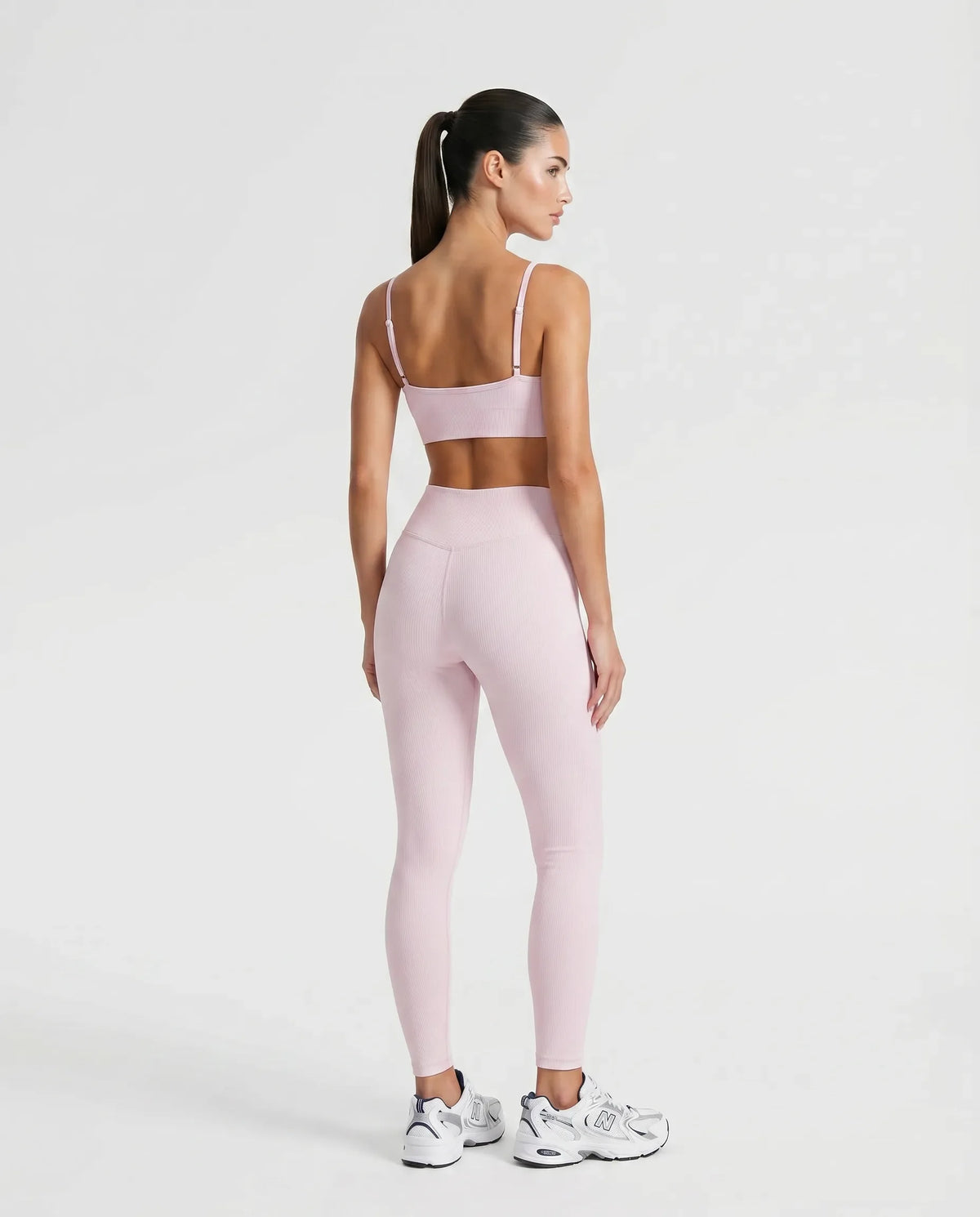 Ghost mannequin back view of pink ribbed bra top showing crossed strap detail and seamless finish.