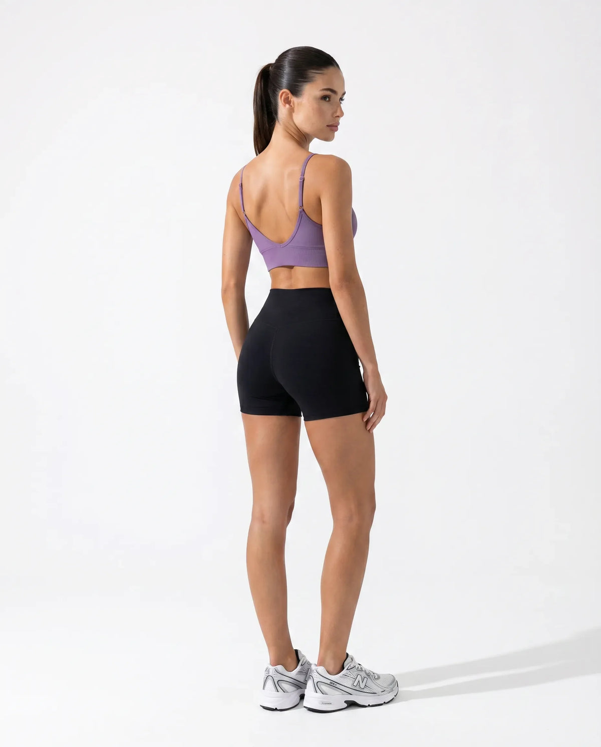 Ghost mannequin back view of purple seamless bra top and high waist leggings displaying thin strap detail and smooth back construction.