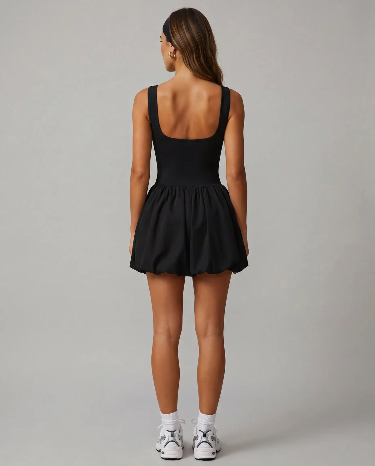 Back view of black balloon mini dress showing wide straps and gathered skirt on ghost mannequin.