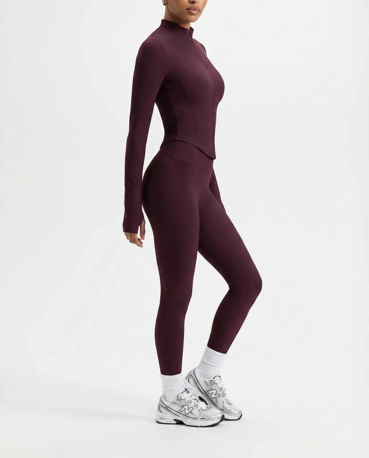 Plus size model front view wearing the wine red zip-up jacket top styled with matching high waist leggings.