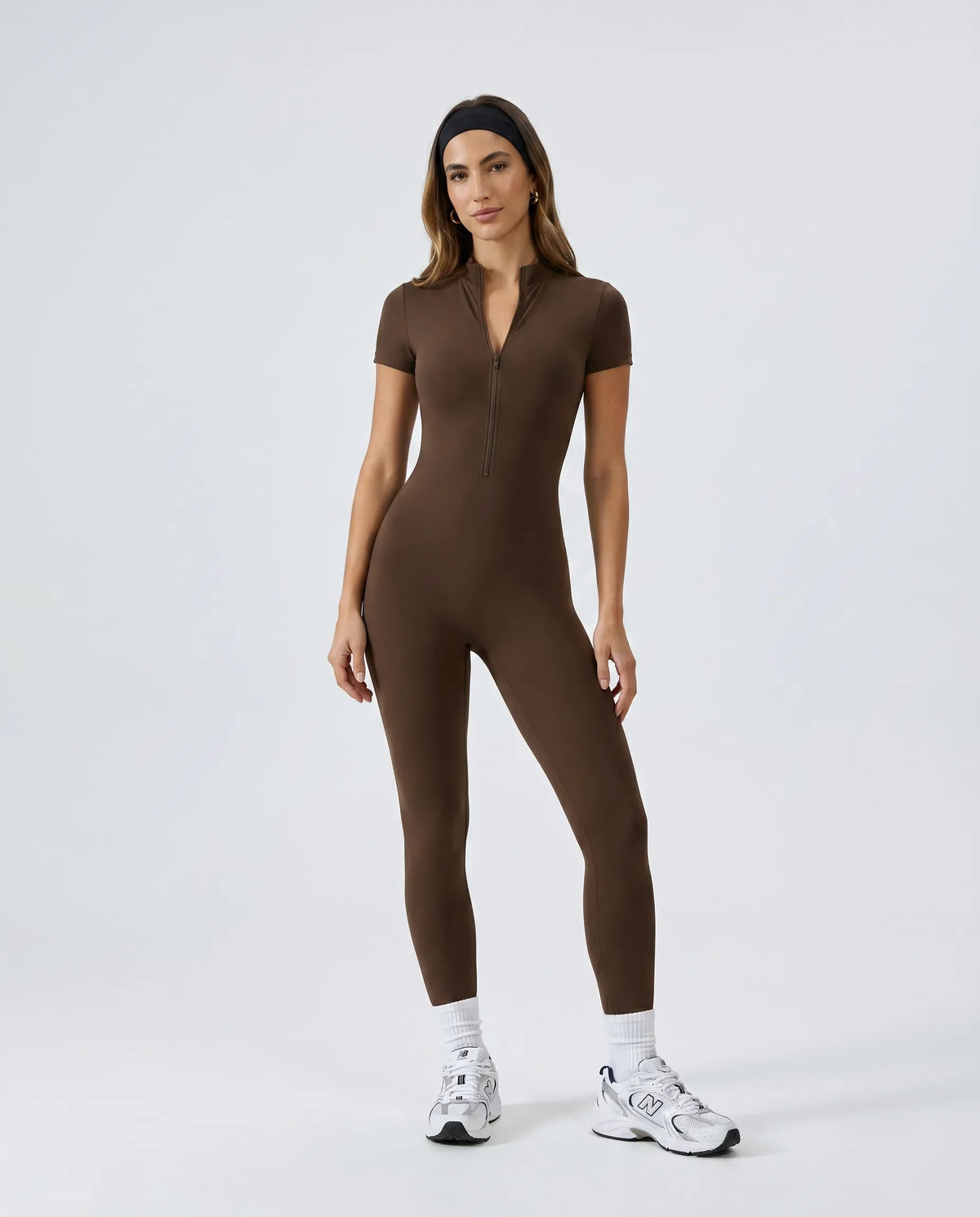Ghost mannequin front view of black short-sleeve zip-front sculpting jumpsuit showing half-zip neckline and full-length legs.