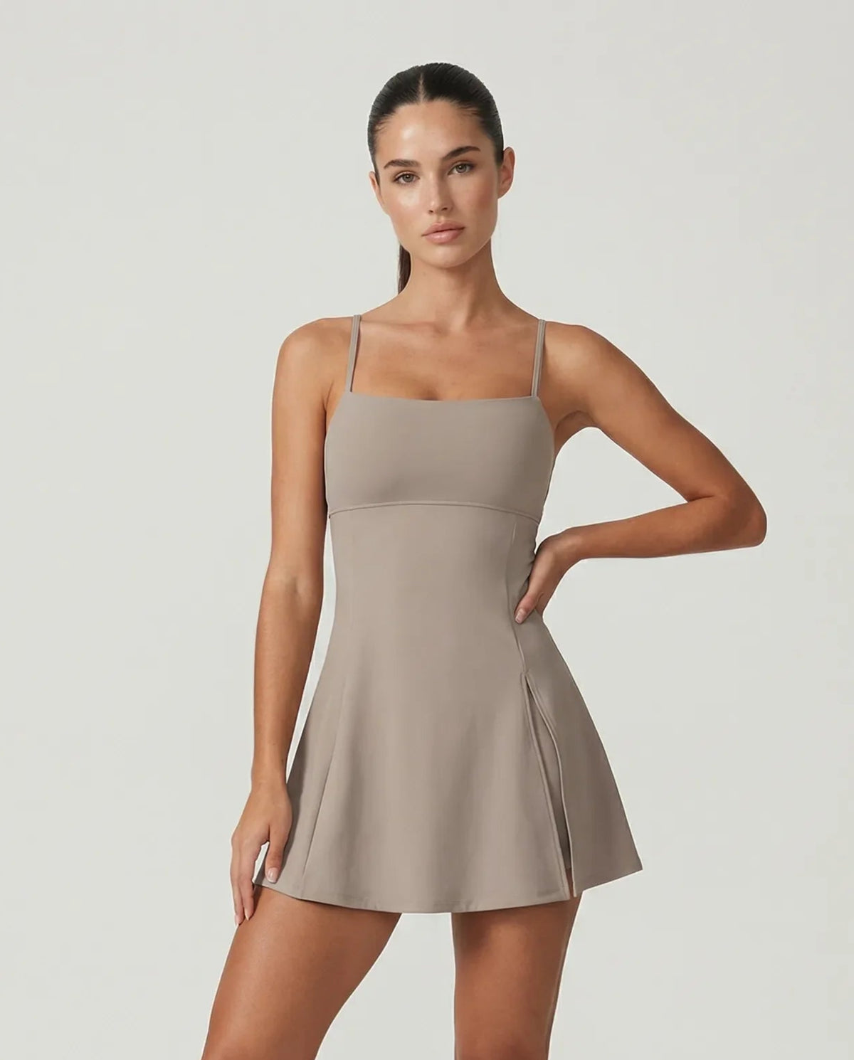 Women's grey padel dress with thin straps and A-line skirt displayed on ghost mannequin, front view.