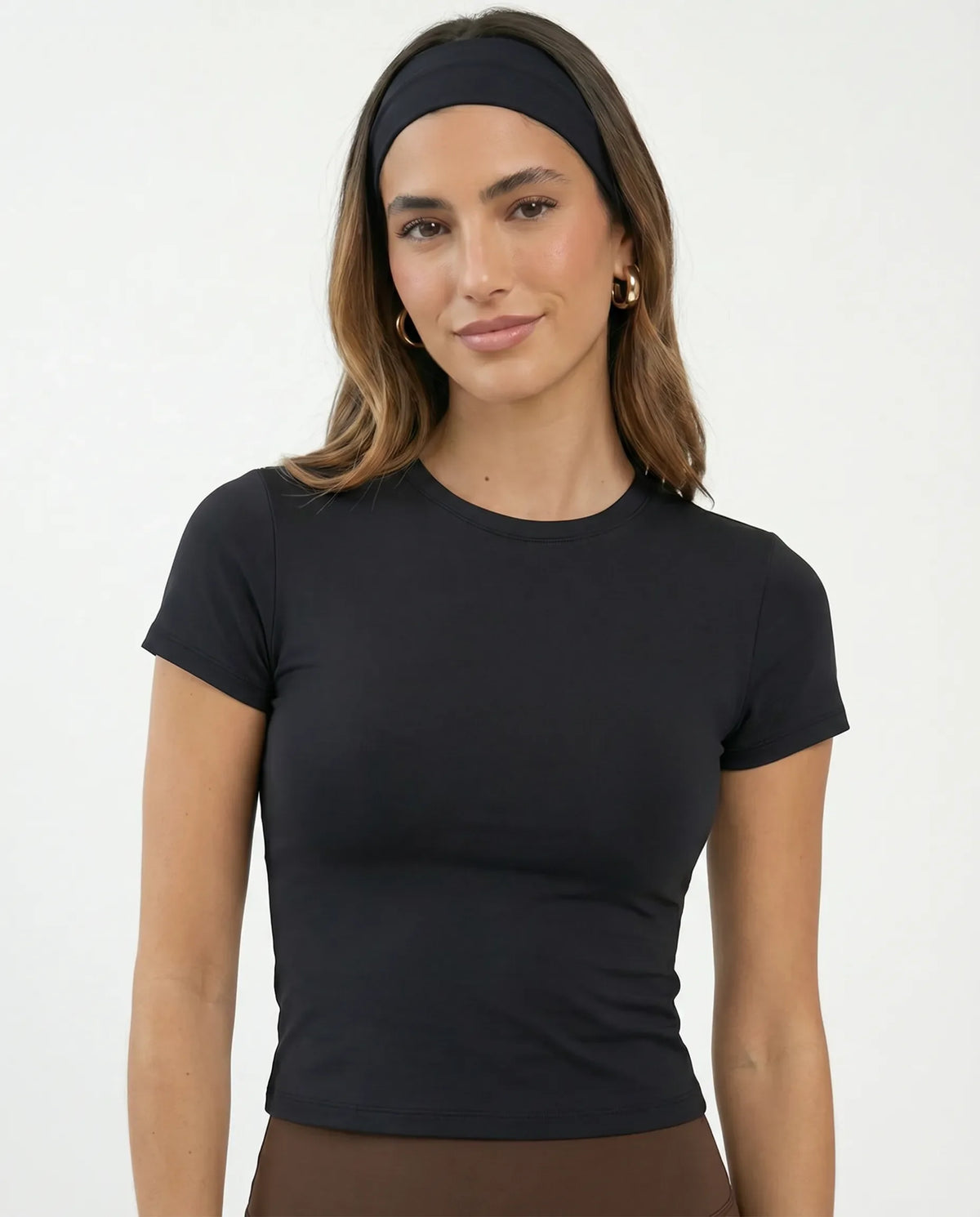 Ghost mannequin back view of the black fitted t-shirt top displaying smooth seam construction and tapered hem.