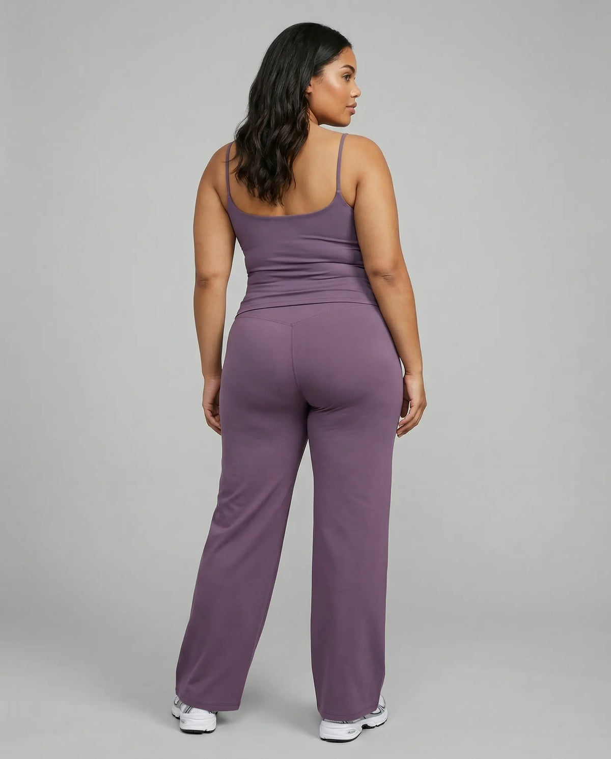 Curvy model wearing mauve high waist crossover wide leg leggings with matching tank top, back view