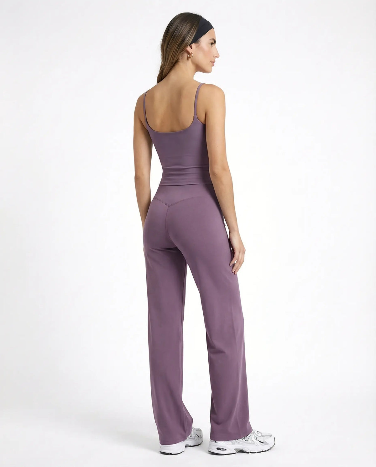 Model wearing mauve high waist crossover wide leg leggings with matching tank top, back view showing V-stitch detail.