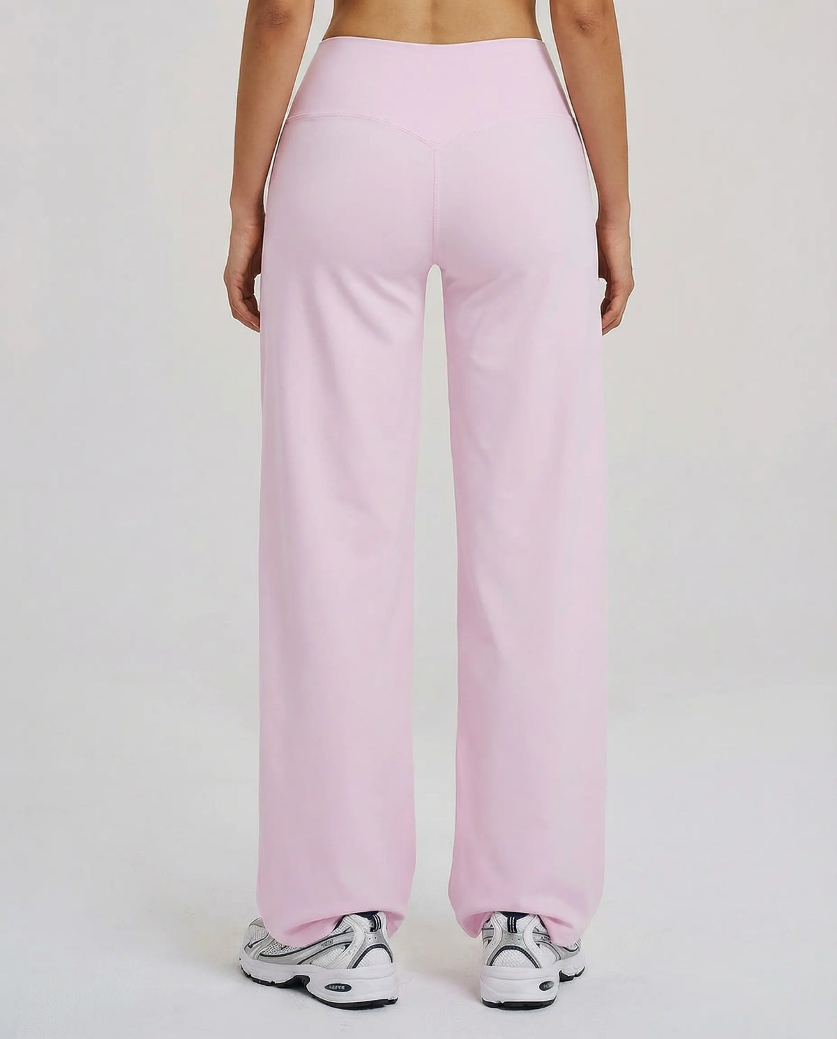 Back view of model wearing pink high waist crossover wide leg leggings, showing V-stitch waistband detail.