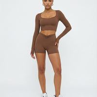 Seen women's activewear set with sculpting brown biker shorts and long sleeve top, designed for workout and active wear.