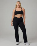 Black women's activewear set with flare leggings and matching sports bra from seen, designed for yoga and sculpt fit workouts.