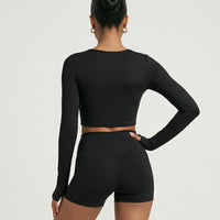 Seen women's activewear set with sculpting biker shorts and long sleeve top, shown from the back in a fitted, athletic style.
