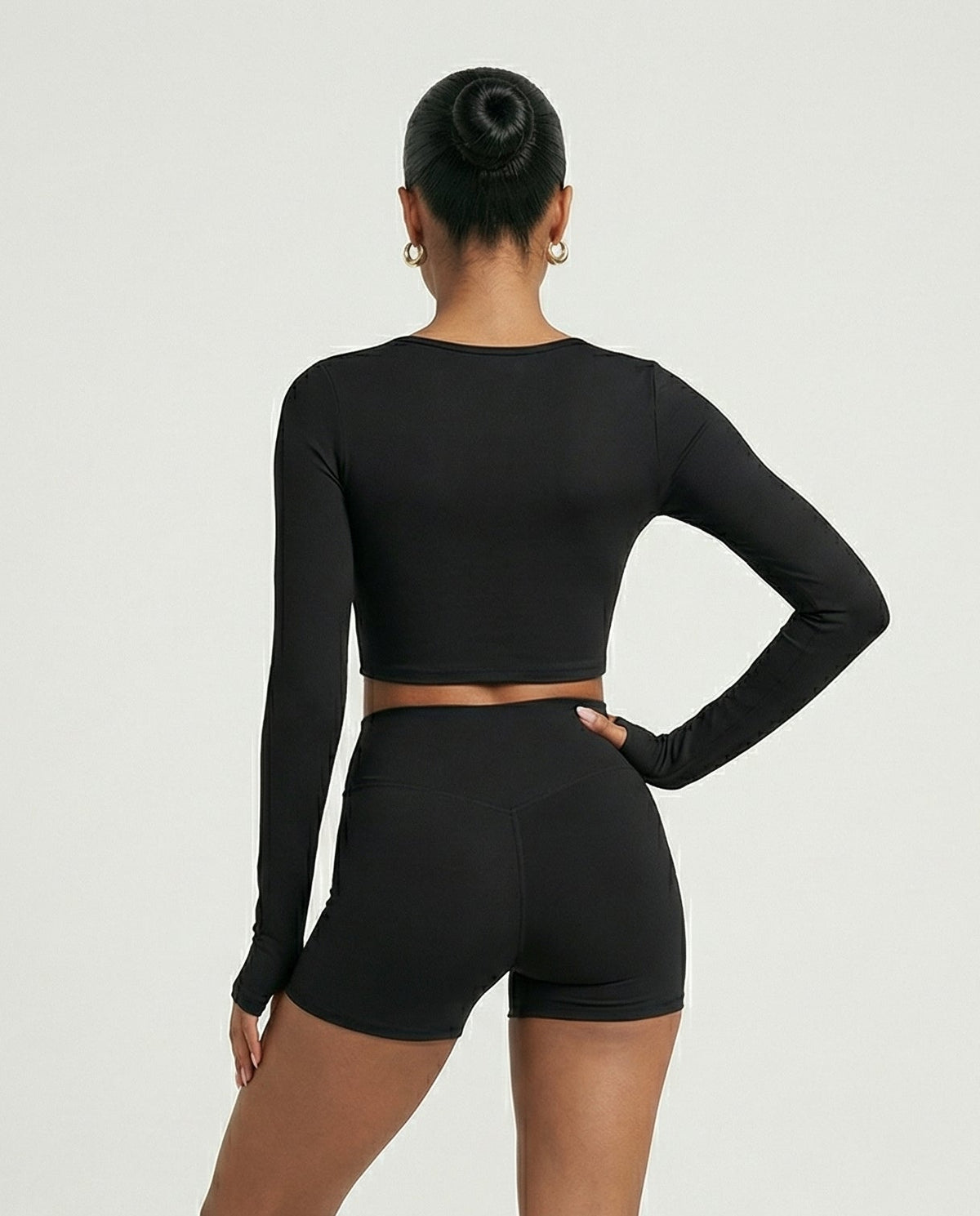 Seen women's activewear set with sculpting biker shorts and long sleeve top, shown from the back in a fitted, athletic style.