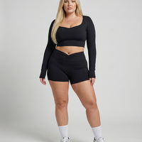 Seen women's activewear set with black sculpting biker shorts and long sleeve top, designed for comfortable workouts.