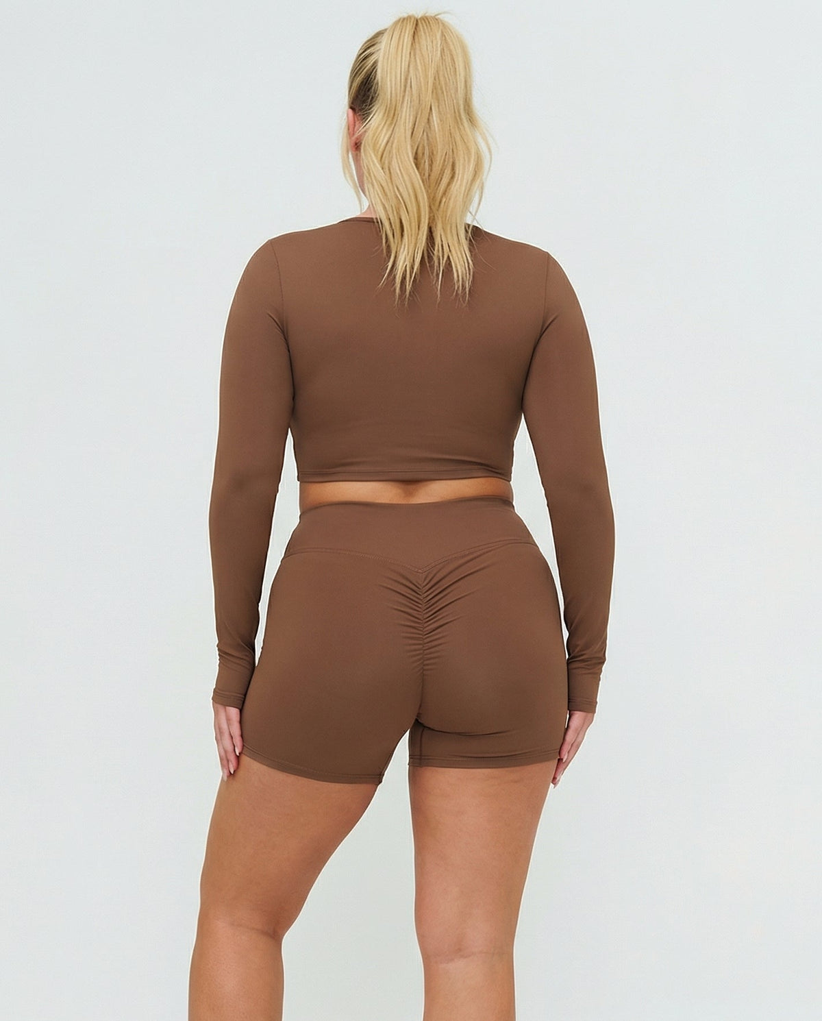 Seen women's activewear set with brown sculpting biker shorts and long sleeve top, designed for comfort and support.