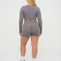 Seen women's activewear set with grey sculpting biker shorts and long sleeve top, designed for workout comfort and style.