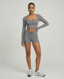 Seen women's activewear set with black biker shorts and long sleeve top, designed for sculpting and workout comfort.