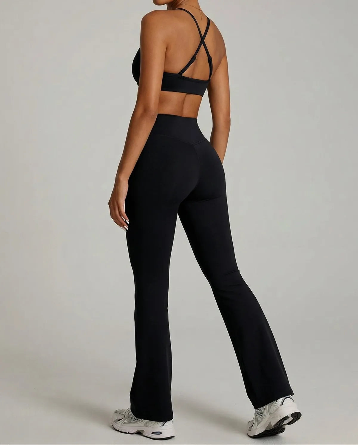 Seen women's activewear set with black flare leggings and matching sports bra, shown from the back for yoga and fitness.