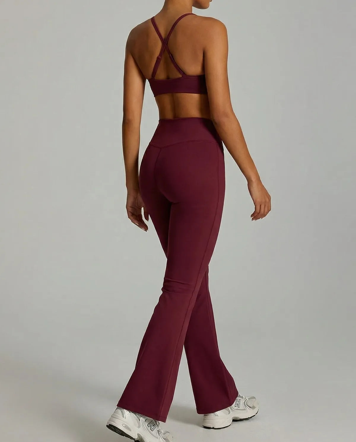 Red yoga flare leggings and matching sculpt-fit sports bra from seen women's activewear set, back view.