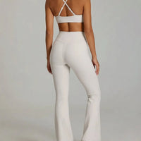 White women's activewear set with flare leggings and matching bra, seen from the back, designed for yoga and sculpt fit.