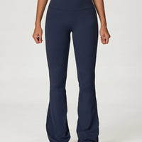 Front view of navy high waist flare leggings with sculpting waistband and bootcut silhouette, paired with neutral sneakers.