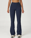 Front view of navy high waist flare leggings with sculpting waistband and bootcut silhouette, paired with neutral sneakers.