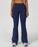 Front view of navy flare high waist sculpting yoga leggings with a smooth compression waistband and sweeping flare leg, paired with grey sneakers.