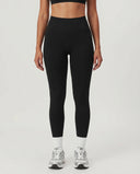 Front view of seamless high waist sculpting compression leggings in black, featuring a wide ribbed waistband and ankle-length squat-proof fit paired with white socks and silver sneakers.